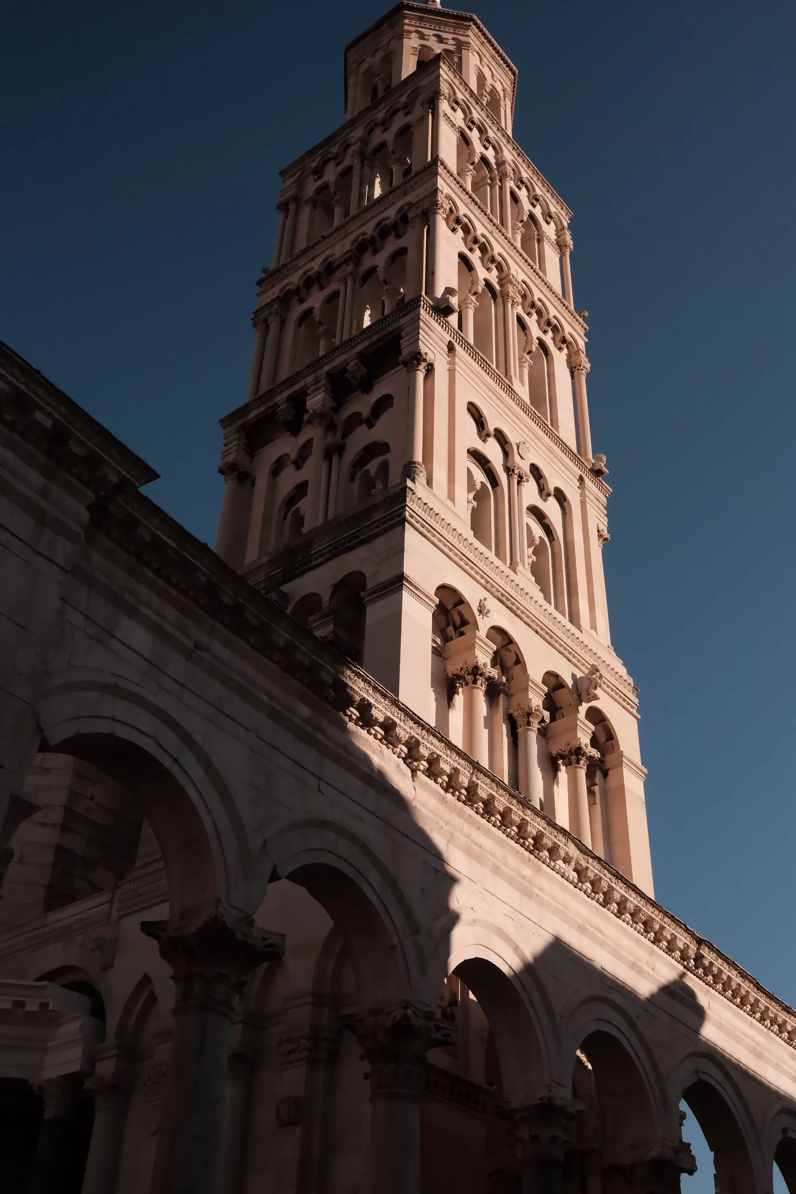 The Romanesque bell tower of Split's cathedral against a clear sky.